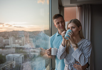 Image showing young couple enjoying evening coffee by the window