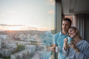 Image showing young couple enjoying evening coffee by the window