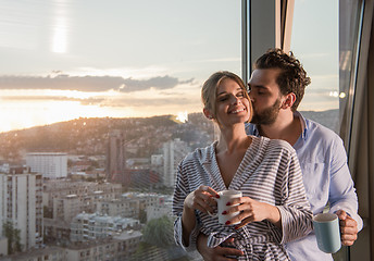 Image showing young couple enjoying evening coffee by the window