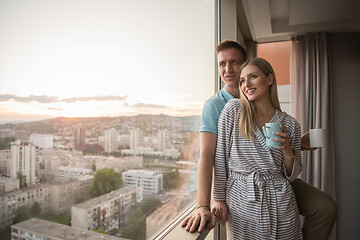 Image showing young couple enjoying evening coffee by the window