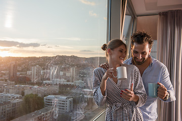 Image showing young couple enjoying evening coffee by the window