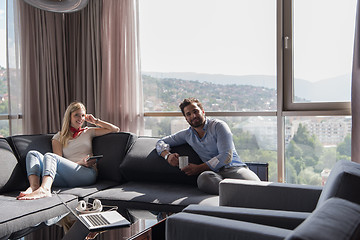 Image showing couple relaxing at  home using tablet computer