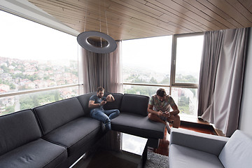 Image showing two young men using a mobile phones  at home