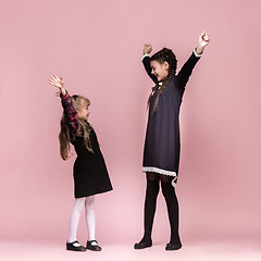 Image showing Cute stylish children on pink studio background. The beautiful teen girls standing together