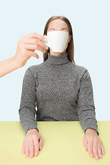 Image showing The coffee break concept. woman before drinking coffee sitting indoor at table at studio