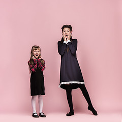 Image showing Cute stylish children on pink studio background. The beautiful teen girls standing together