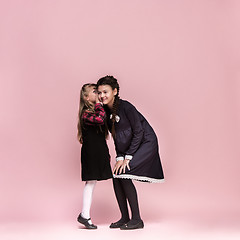 Image showing Cute stylish children on pink studio background. The beautiful teen girls standing together