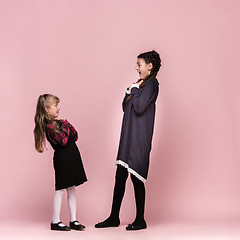 Image showing Cute stylish children on pink studio background. The beautiful teen girls standing together