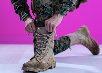 Image showing soldier tying the laces on his boots