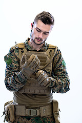Image showing closeup of soldier hands putting protective battle gloves