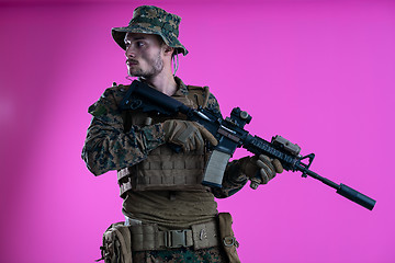 Image showing soldier in action aiming laseer sight optics pink background