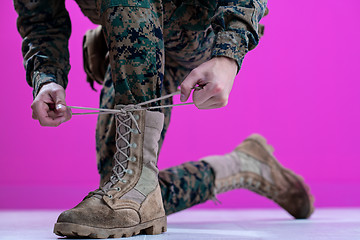 Image showing soldier tying the laces on his boots