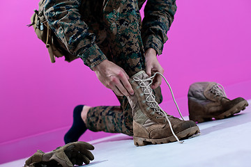 Image showing soldier tying the laces on his boots