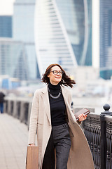 Image showing attractive middle-aged woman in a light coat smiles