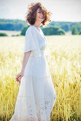 Image showing happy smiling middle-aged woman in a white summer dress standing