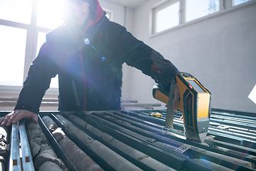 Image showing team of mining  workers measuring drilled rock core