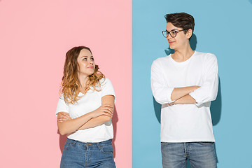 Image showing Young emotional man and woman on pink and blue background