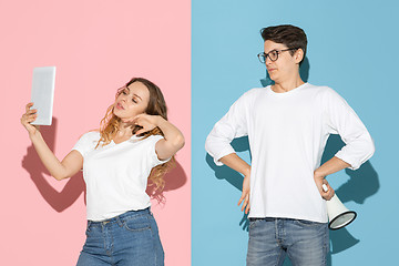 Image showing Young emotional man and woman on pink and blue background