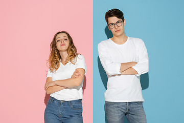 Image showing Young emotional man and woman on pink and blue background