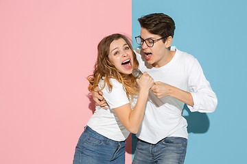 Image showing Young emotional man and woman on pink and blue background