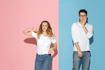 Image showing Young emotional man and woman on pink and blue background