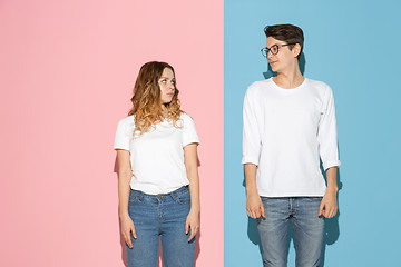 Image showing Young emotional man and woman on pink and blue background