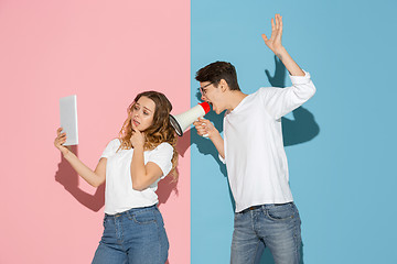 Image showing Young emotional man and woman on pink and blue background