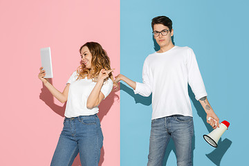 Image showing Young emotional man and woman on pink and blue background