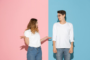 Image showing Young emotional man and woman on pink and blue background