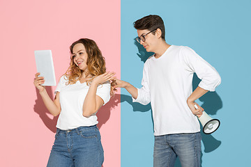 Image showing Young emotional man and woman on pink and blue background