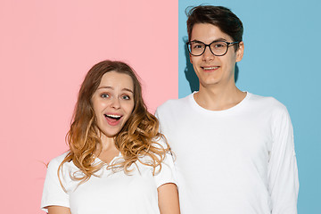 Image showing Young emotional man and woman on pink and blue background