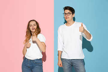 Image showing Young emotional man and woman on pink and blue background