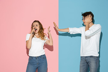 Image showing Young emotional man and woman on pink and blue background