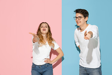 Image showing Young emotional man and woman on pink and blue background