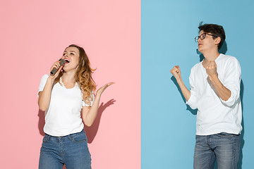 Image showing Young emotional man and woman on pink and blue background