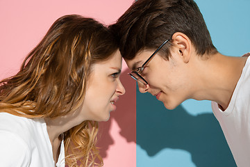 Image showing Young emotional man and woman on pink and blue background