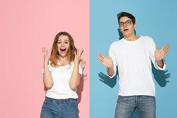 Image showing Young emotional man and woman on pink and blue background