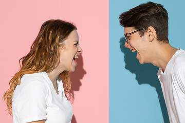 Image showing Young emotional man and woman on pink and blue background