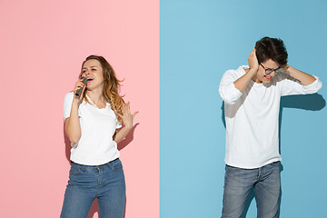 Image showing Young emotional man and woman on pink and blue background