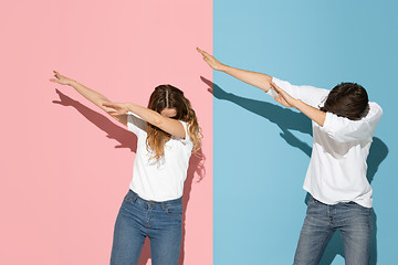 Image showing Young emotional man and woman on pink and blue background