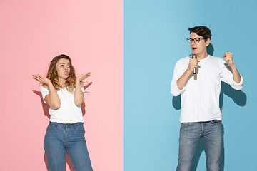 Image showing Young emotional man and woman on pink and blue background