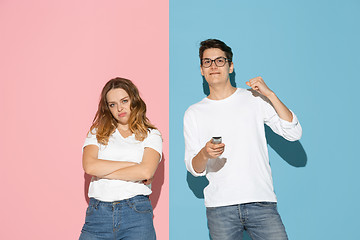 Image showing Young emotional man and woman on pink and blue background