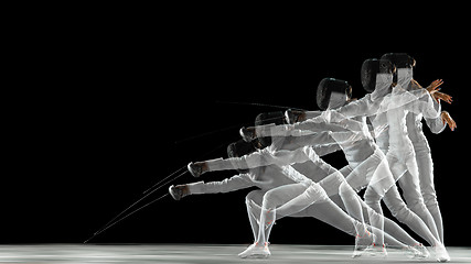 Image showing Teen girl in fencing costume with sword in hand isolated on black background