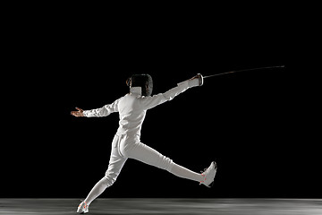 Image showing Teen girl in fencing costume with sword in hand isolated on black background