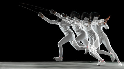 Image showing Teen girl in fencing costume with sword in hand isolated on black background