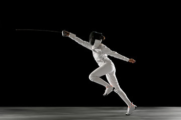 Image showing Teen girl in fencing costume with sword in hand isolated on black background