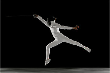 Image showing Teen girl in fencing costume with sword in hand isolated on black background