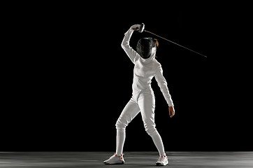 Image showing Teen girl in fencing costume with sword in hand isolated on black background