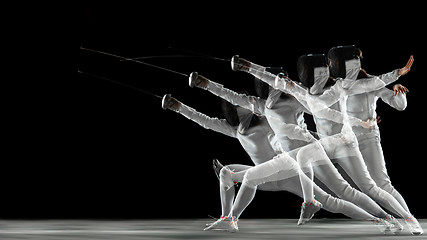 Image showing Teen girl in fencing costume with sword in hand isolated on black background