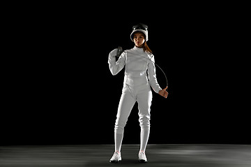 Image showing Teen girl in fencing costume with sword in hand isolated on black background